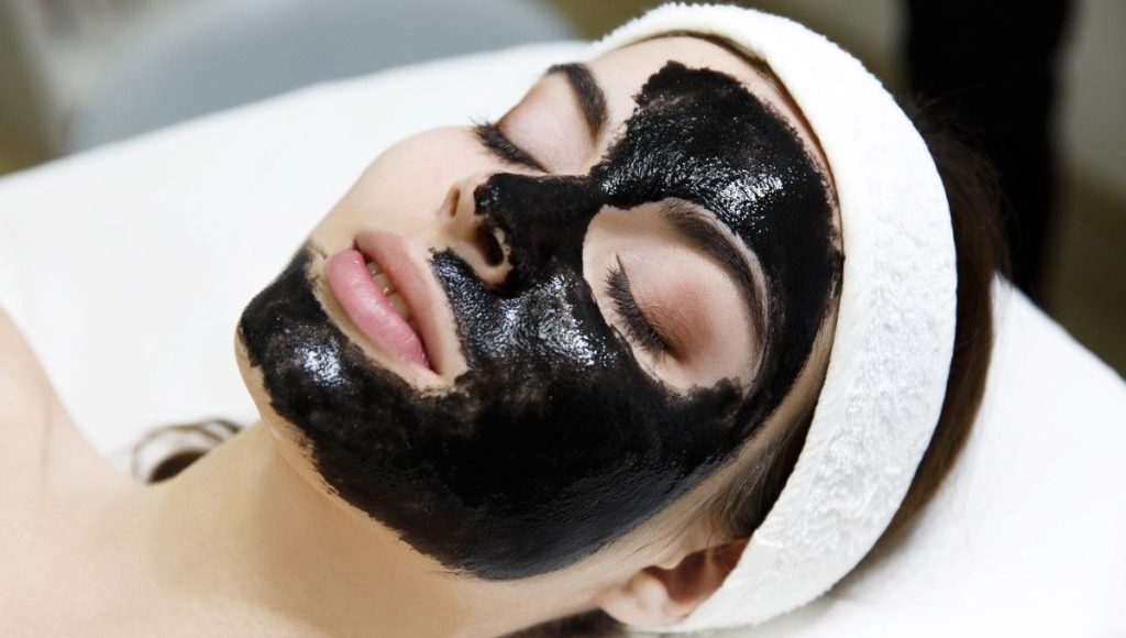 mujer con mascarilla de carbon en el rostro foto hollywood peel